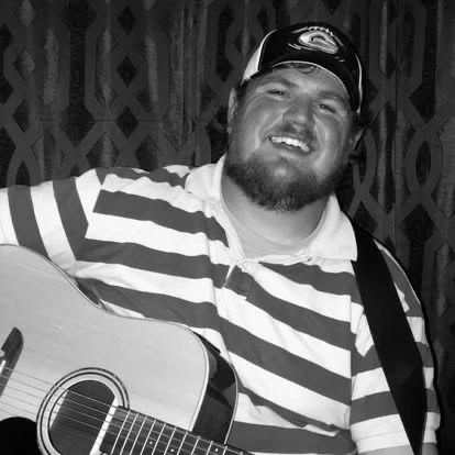 Scotty Sams smiling with guitar